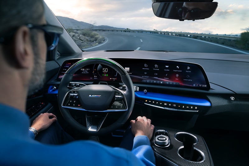 Front View of the 2026 OPTIQ-V Driving Through the Dusk Utilizing its Headlights | Bomnin Cadillac Homestead in Homestead FL